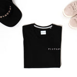 T-shirt nera con logo rosa abbinata alle sneakers rosa e al cappello