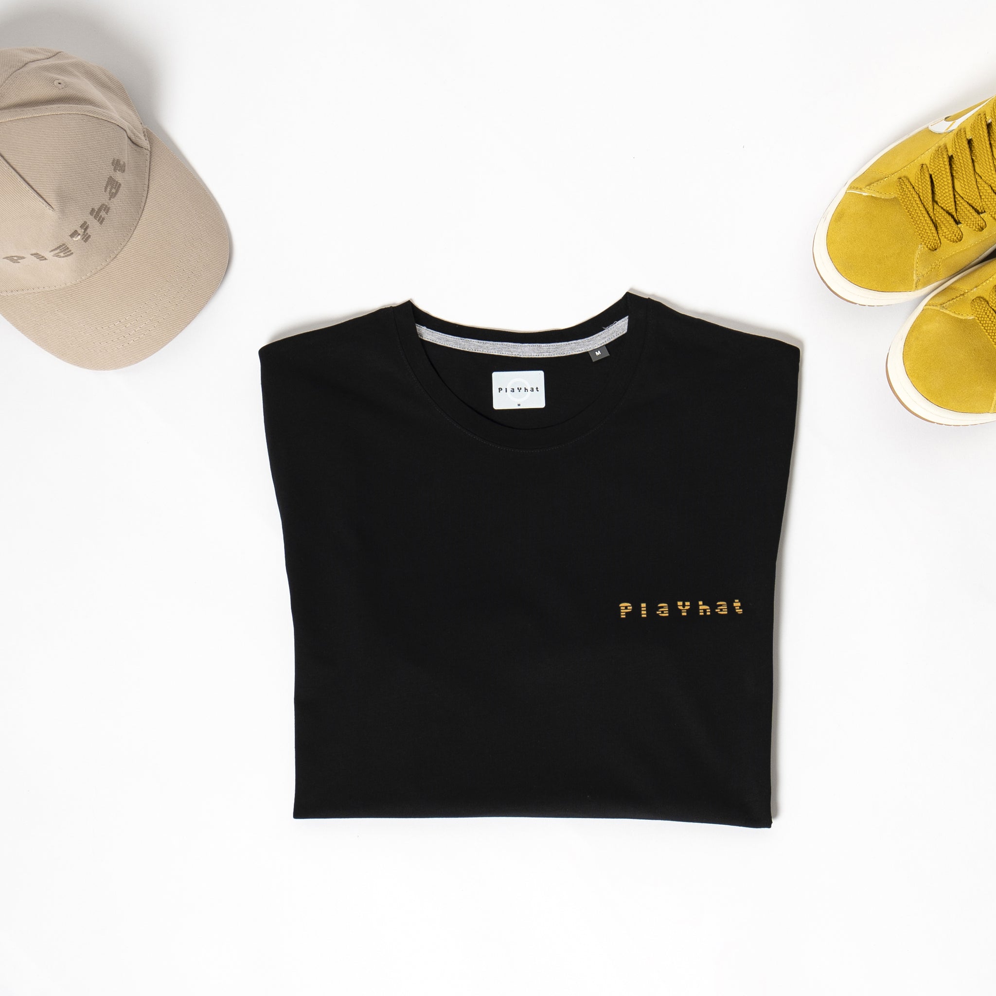 T-shirt con logo giallo abbinata alle sneakers gialle e al cappello